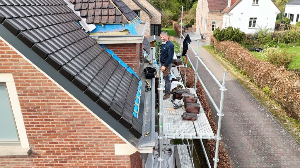 Dakwerker plaatst nieuwe pannen vanaf de stelling