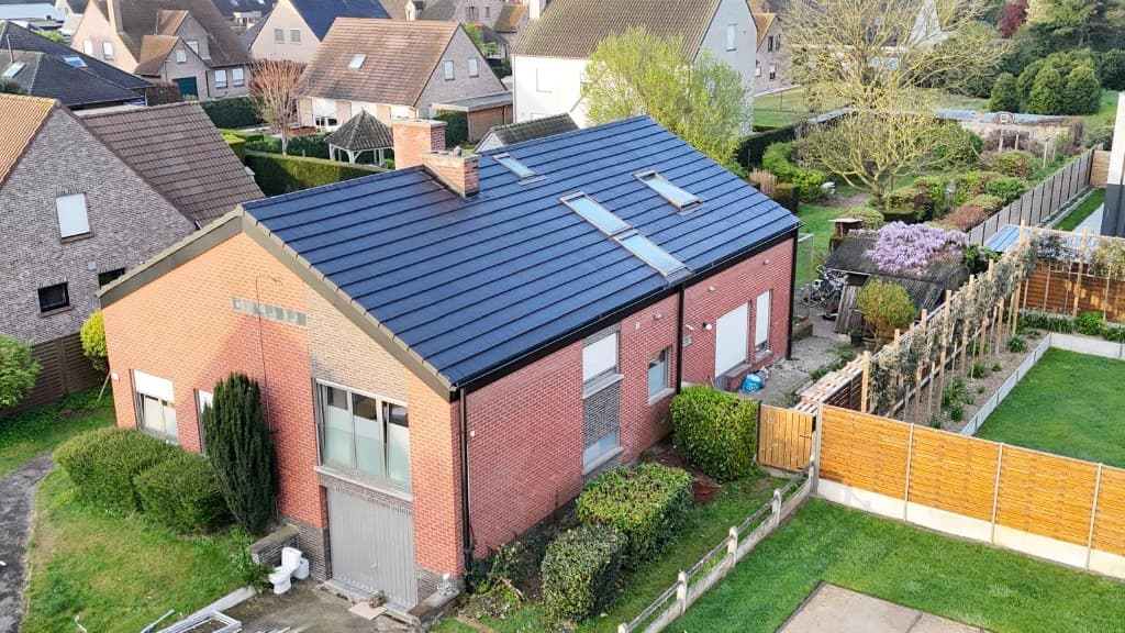 Afgewerkt hellend dak met donkere pannen, dakramen en schouw