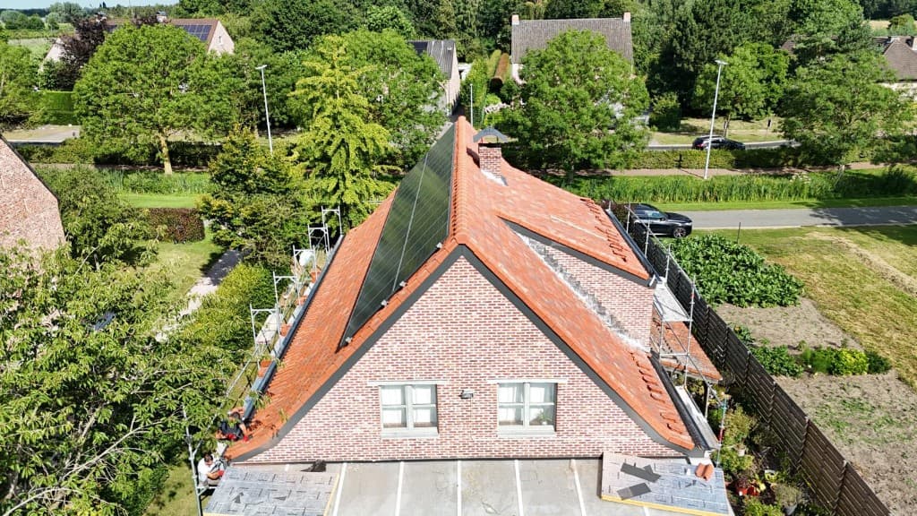 Nieuw terracotta pannendak met zonnepanelen op de kopgevel