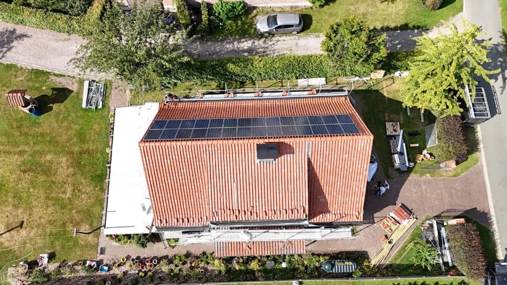 Bovenaanzicht van een pannendak met een rij zonnepanelen
